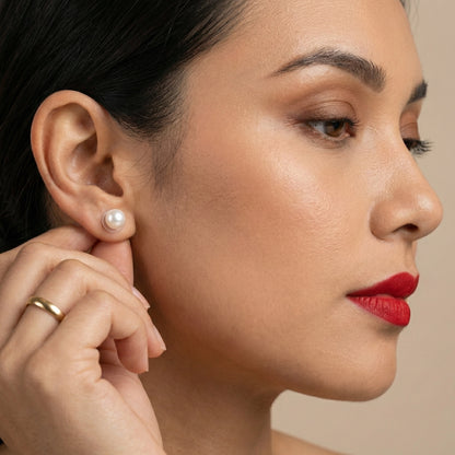 Simple round pearl earrings in a clean product photography setup