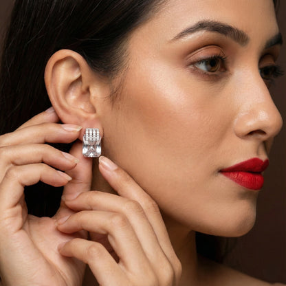Close-up of a woman wearing a diamond earring with a dark background