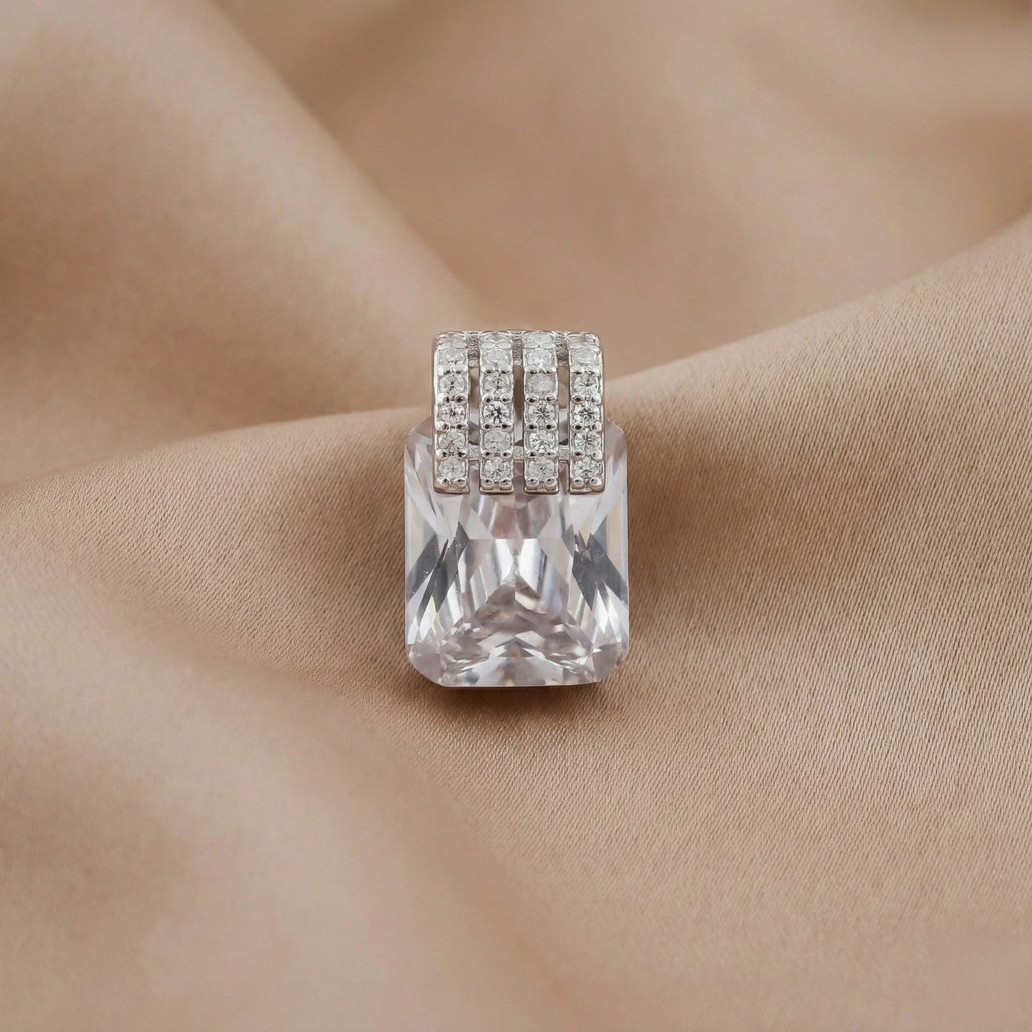 Silver ring with a large clear gemstone on a beige fabric background