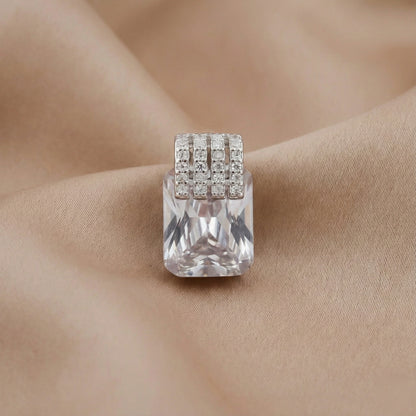 Silver ring with a large clear gemstone on a beige fabric background