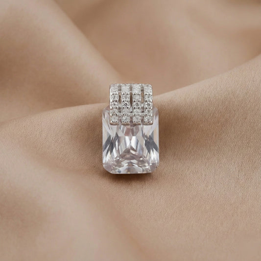 Silver ring with a large clear gemstone on a beige fabric background